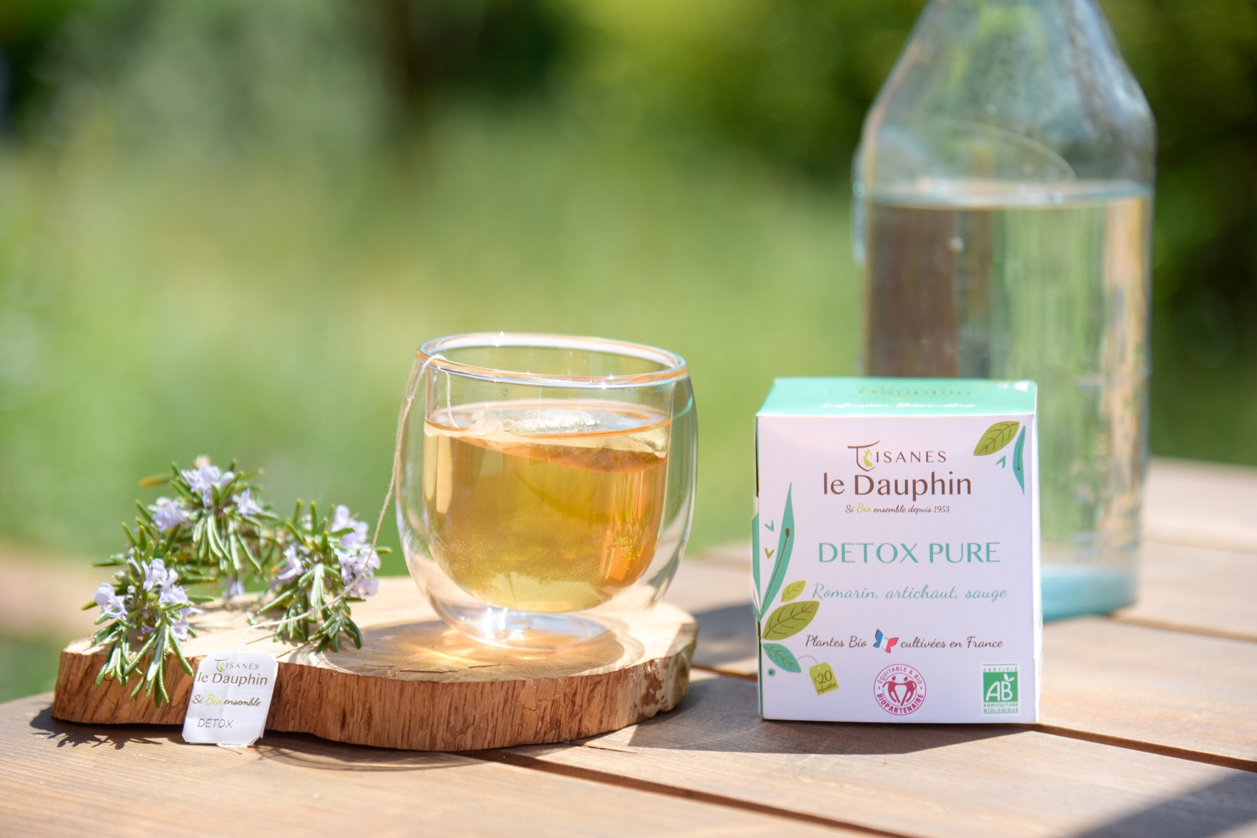 Infusion Détox Pure des Tisanes le Dauphin avec une tasse et une boîte en ambiance extérieure